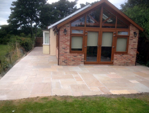 New patio area laid with Bradstone sunset buff sandstone slabs and paved areas using Woburn rumbled Autumn Blocks